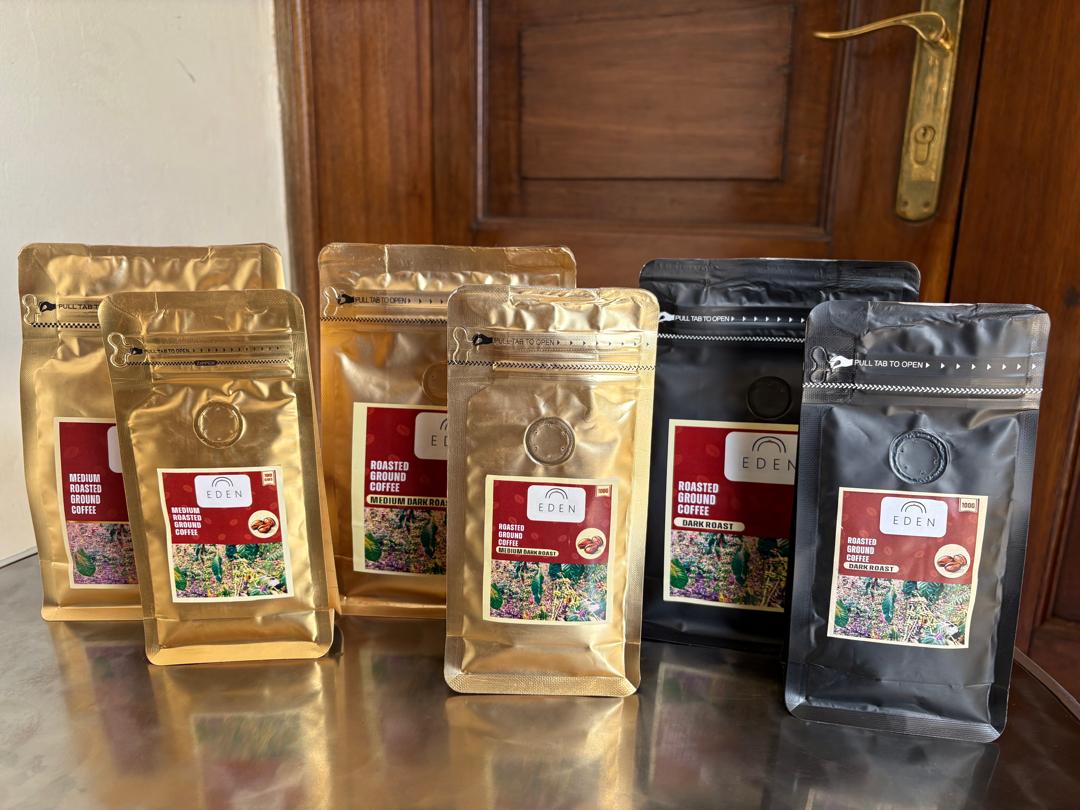 Eden Coffee roasts lined up — medium, medium dark and dark in gold and black resealable pouches